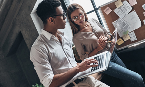 Young confident business people using computer while working in the office