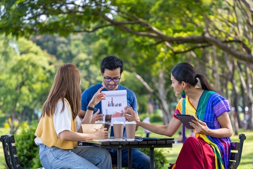 Group of business startup people having a meeting project outside in the public park